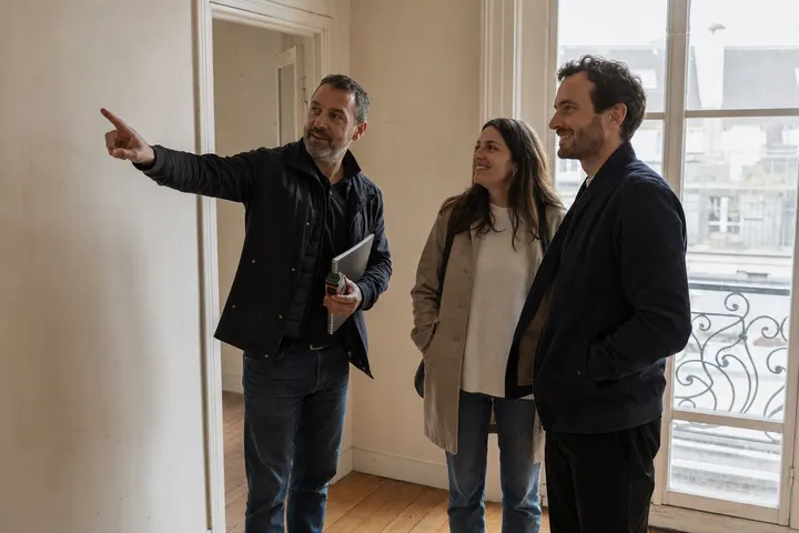 Illustration IA : un chef de projet fait visiter un appartement à un couple avant travaux